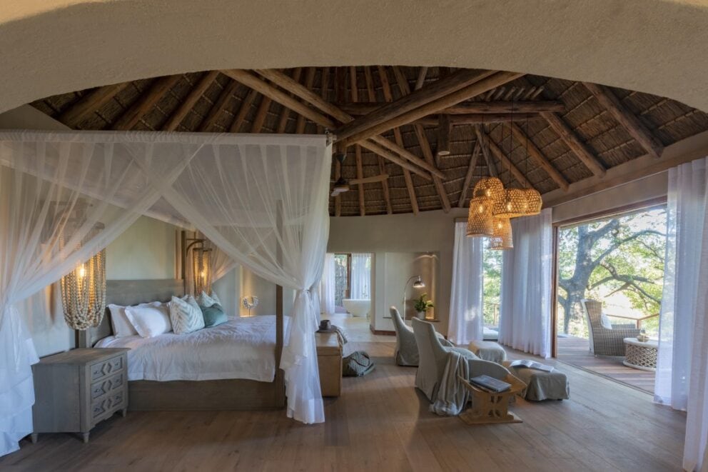 A luxury bedroom suite at Dulini River in Sabi Sands Nature Reserve, South Africa, featuring a view of the African bush.