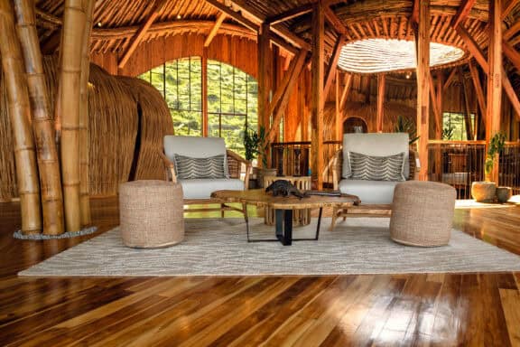 View of the lounge area, featuring plush cushioned armchairs and ottomans at Erebero Hills, Uganda.