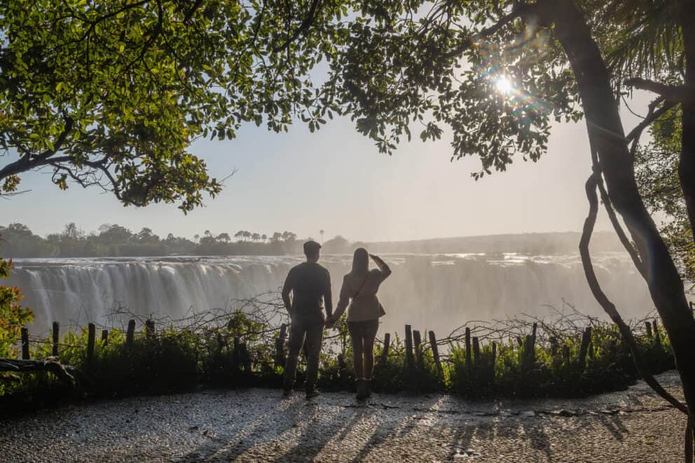 Tourists standing along a pathway, overlooking Victoria Falls at Waterfalls Lodge, Zimbabwe.