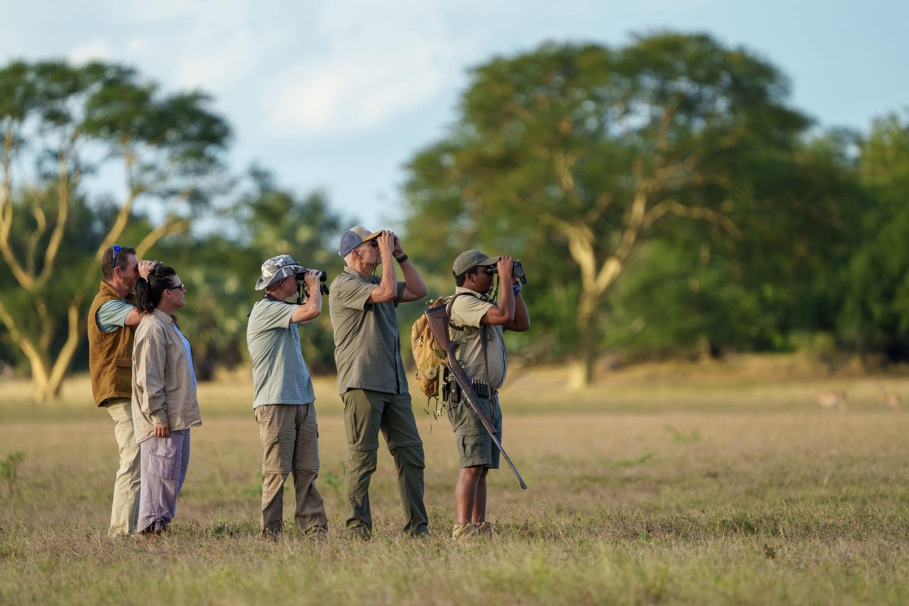 Safari-goers on a walking safari in the bush on a Mozambique honeymoon