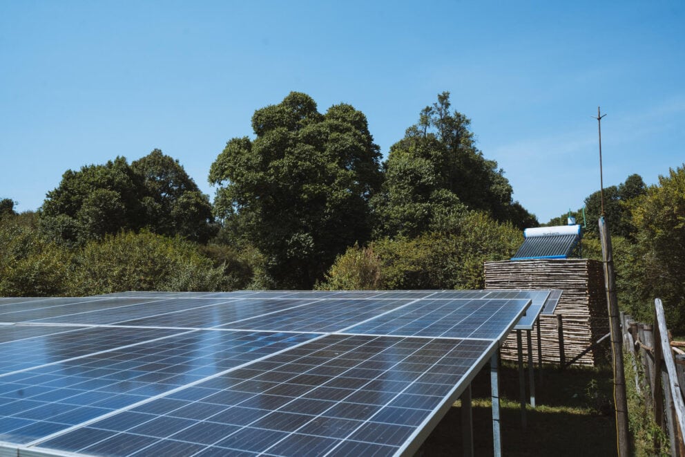 Row of solar panels set up in the open savannah of the Masai Mara.
