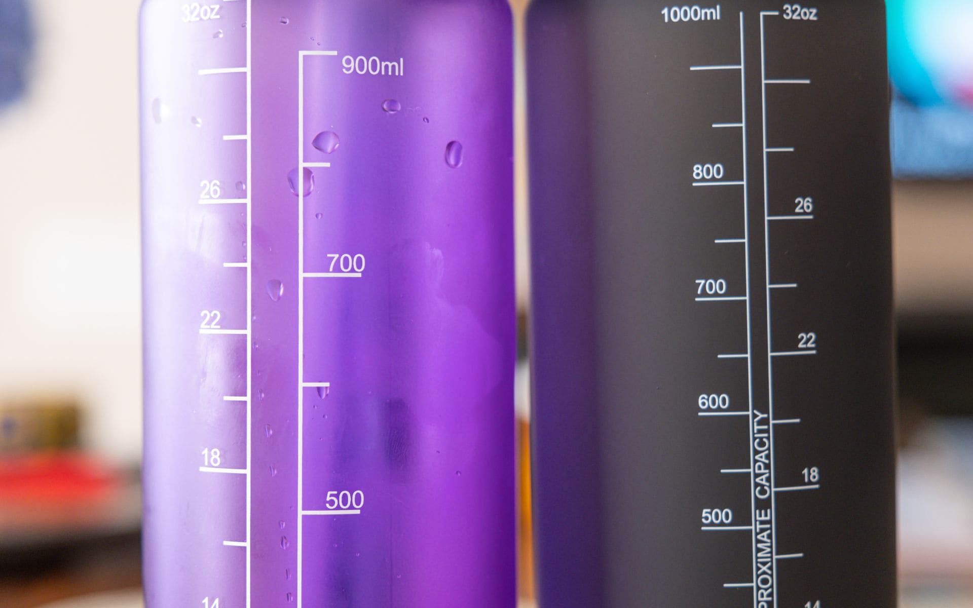 two reusable water bottles. one is black and one is purple