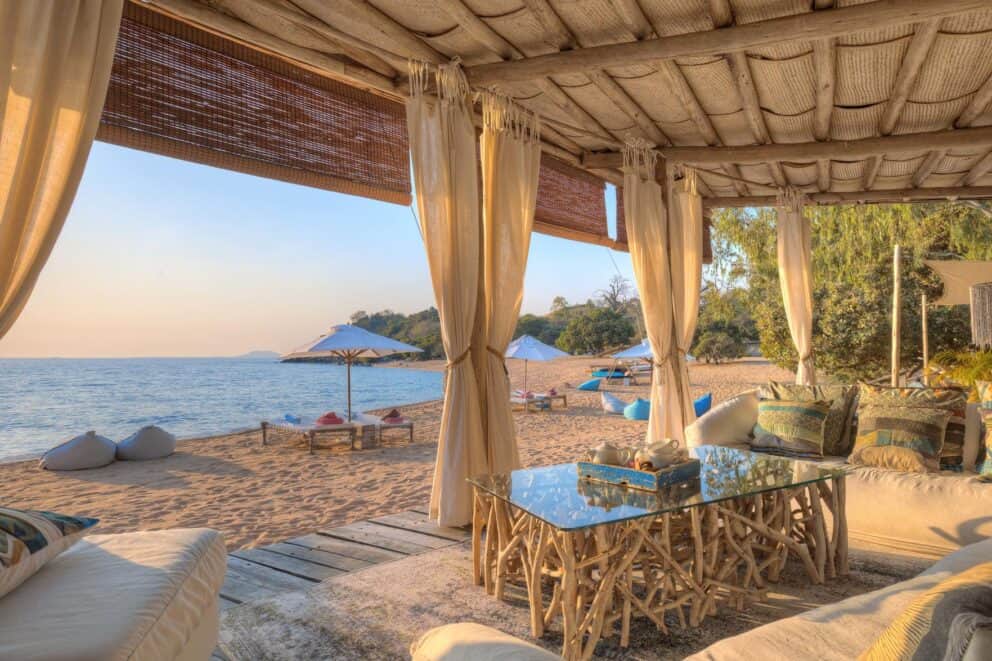 Open-air luxury lounge at Kaya Mawa overlooking the bright blue water of Lake Malawi