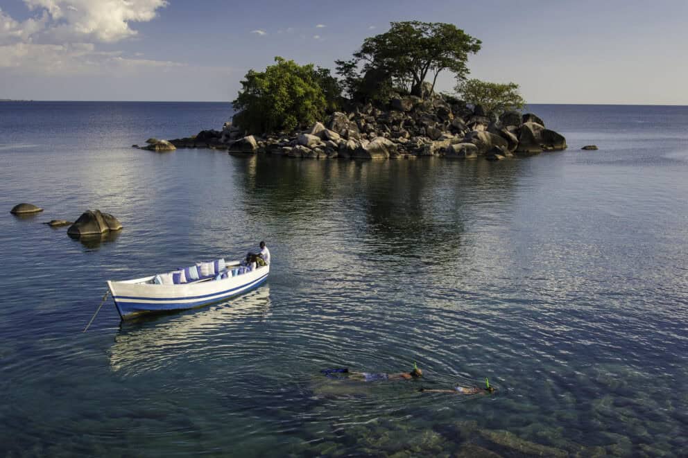Guests snorkelling in the crystal clear water from a boat on Lake Malawi.