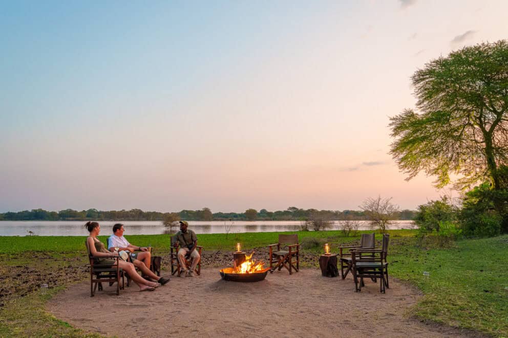 Sitting at a fire pit next to the lake in Liwonde National park