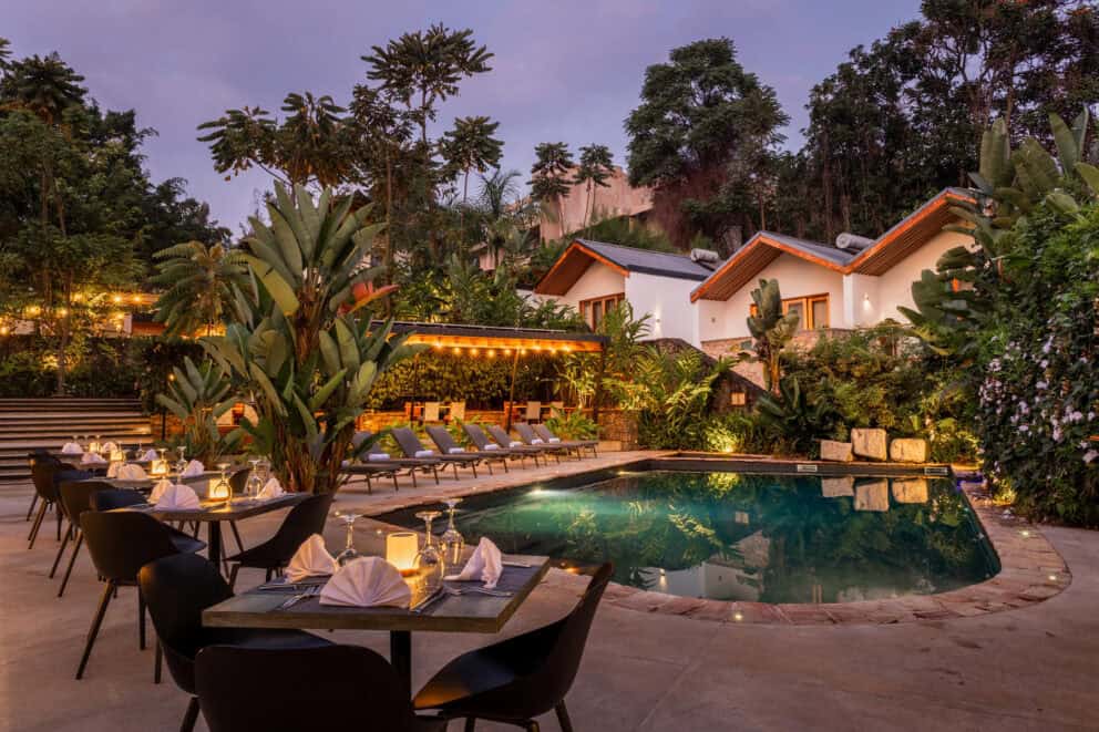 View of the pool area at dusk with lit lanterns and comfy seating at Hemingways Retreat Kigali, Rwanda.