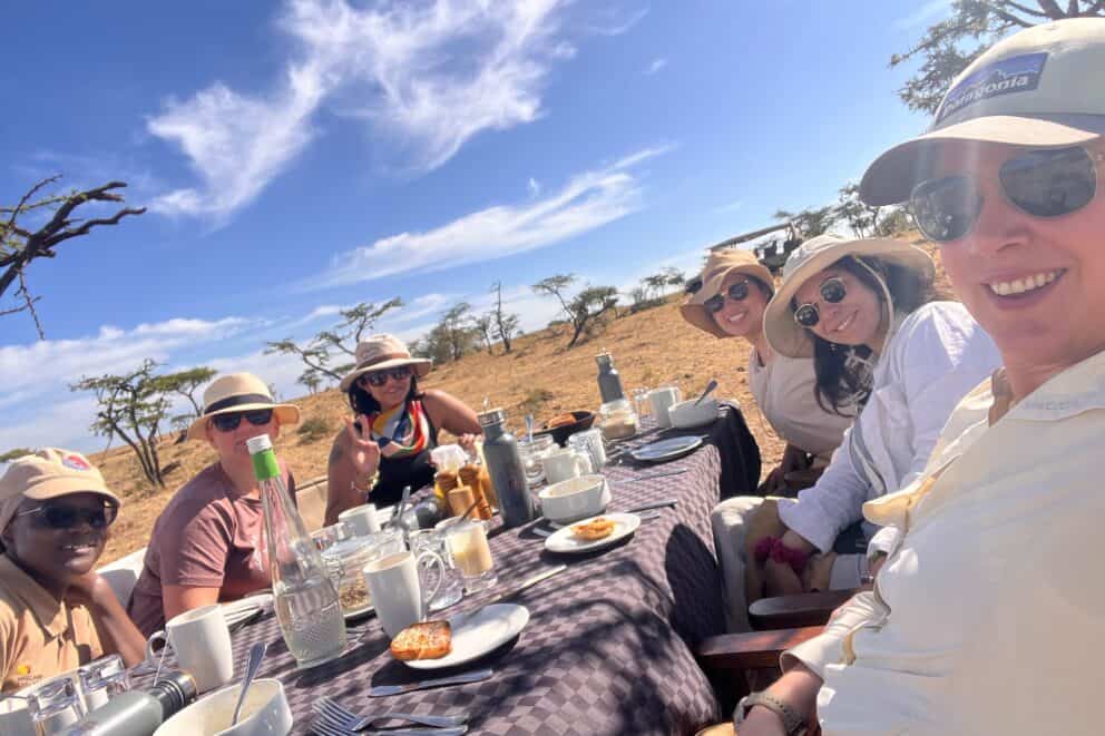 A group of tourists enjoying a bush breakfast in the open plains in Kenya.
