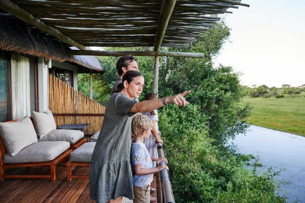 A family standing on the balcony overlooking the Boteti River at Leroo La Tau, Botswana.