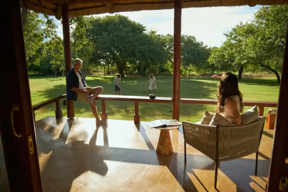 A family at Chobe Chilwero Lodge in Botswana enjoying a game of croquet on the lawn.
