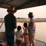A family on a sunset boat cruise on the Chobe River at Chobe Game Lodge, Botswana.