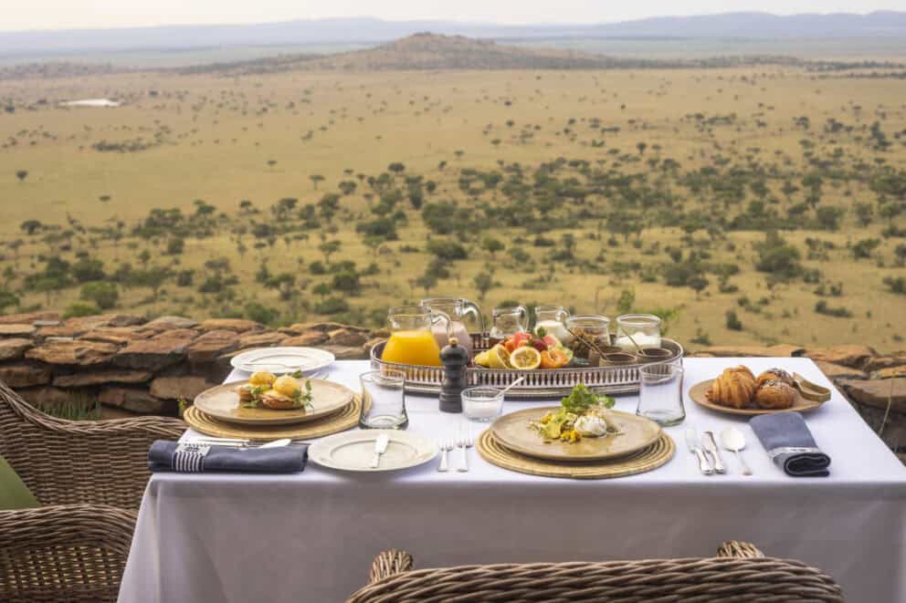An outdoor breakfast served on the verandah overlooking the open plains at Singita Sasakwa Lodge, Tanzania.