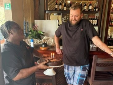 A guest at Kambaku Safari Lodge celebrating his birthday with cake in the Timbavati Private Nature Reserve, South Africa.