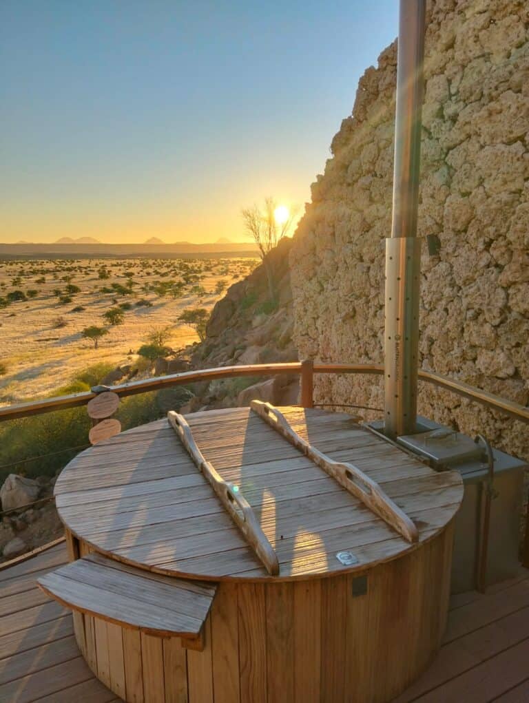 A Japanese hot tub overlooking the landscape of Damaraland at sunset at Onduli Ridge, Namibia.