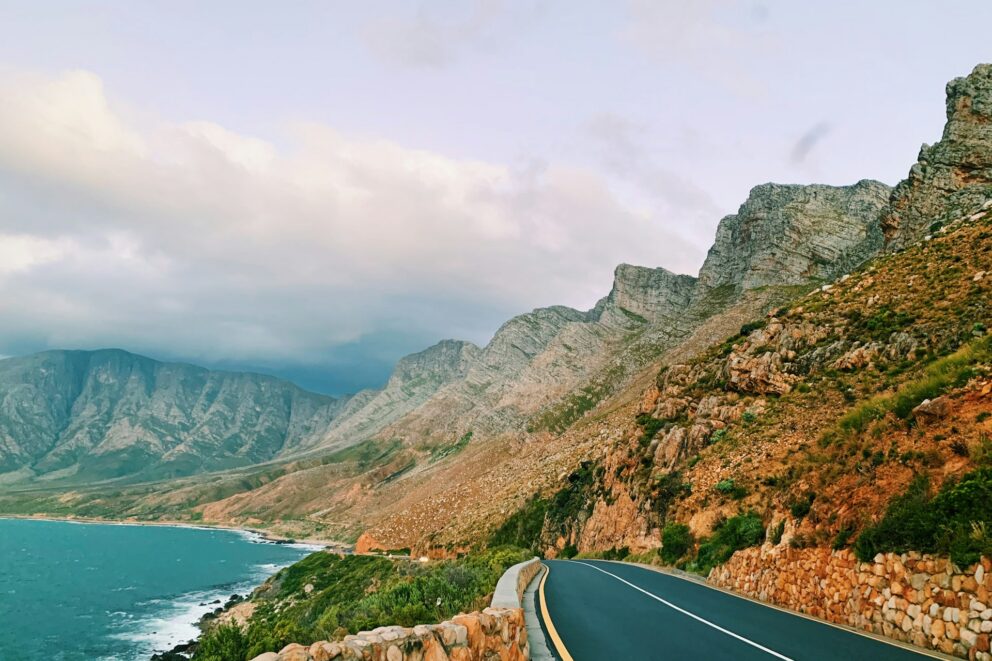 View of a scenic coastal road along the Cape Town coastline, with mountains on one side and the ocean on the other, South Africa.