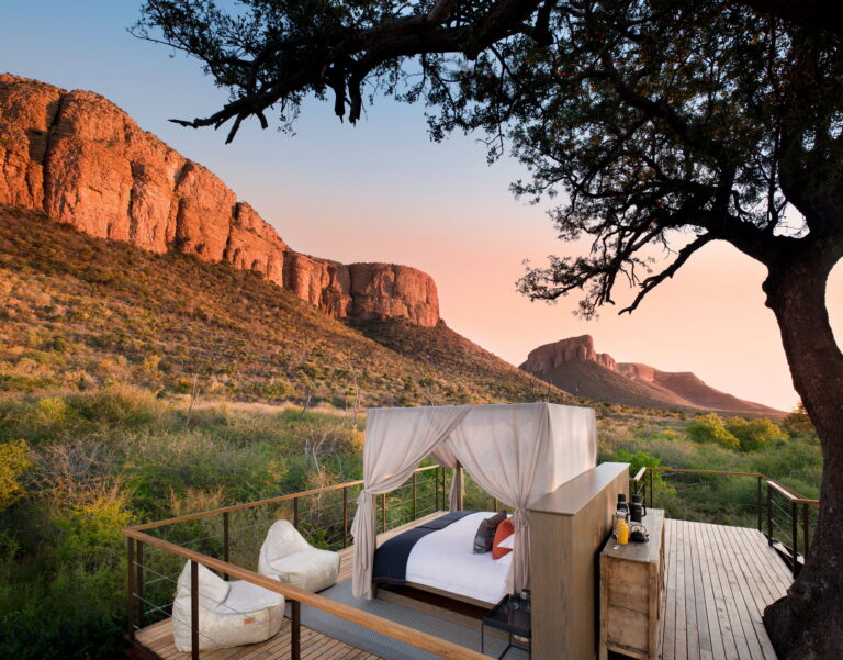 Sunset view of the elevated wooden sleepout deck overlooking the Waterberg Mountains at Marataba Safari Lodge in Marakele National Park, South Africa.